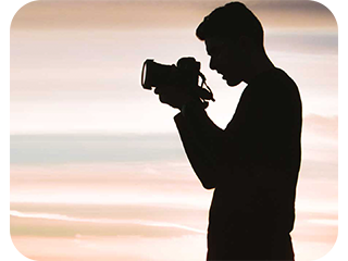 a man silhouette holding a photo camera